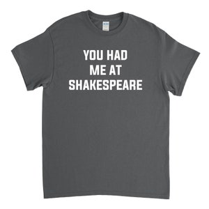 May include: A dark gray t-shirt with the text "You had me at Shakespeare" printed in white.