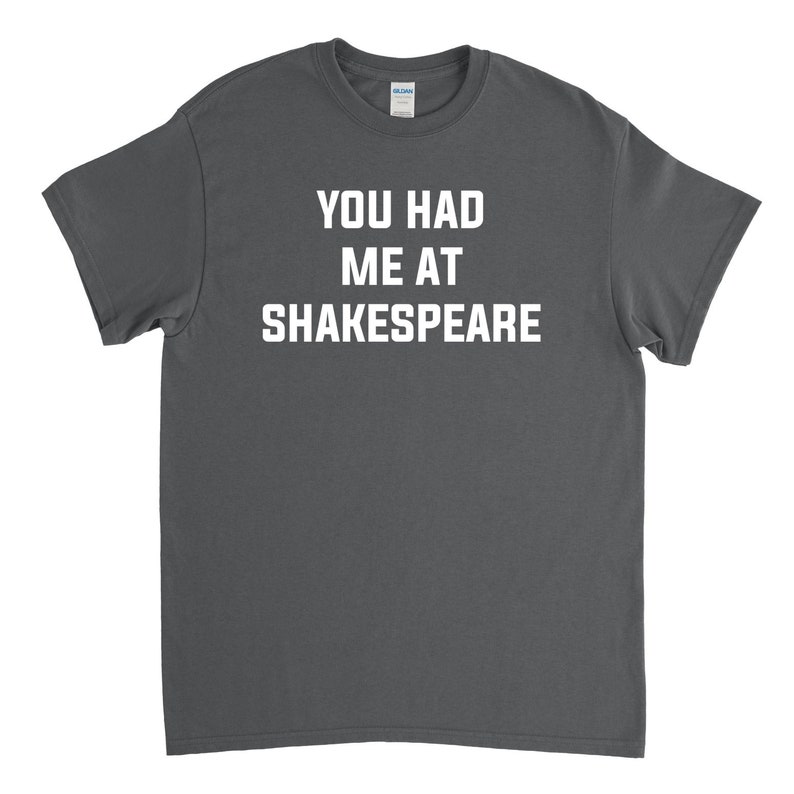 May include: A dark gray t-shirt with the text "You had me at Shakespeare" printed in white.