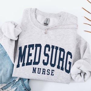 Puede incluir: Una taza de cer&aacute;mica blanca con asa negra y el texto "But First, Coffee" en negro, con una fuente de estilo manuscrito. La taza est&aacute; sobre una superficie blanca.