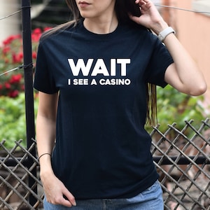Pu&ograve; includere: Una maglietta nera con testo bianco che dice "WAIT I SEE A CASINO".