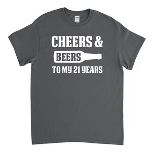 May include: A dark grey t-shirt with white text that reads "Cheers & Beers to my 21 years" and a graphic of a beer bottle.