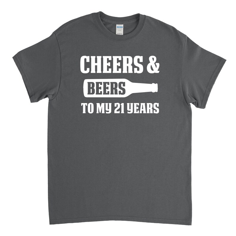 May include: A dark grey t-shirt with white text that reads "Cheers & Beers to my 21 years" and a graphic of a beer bottle.