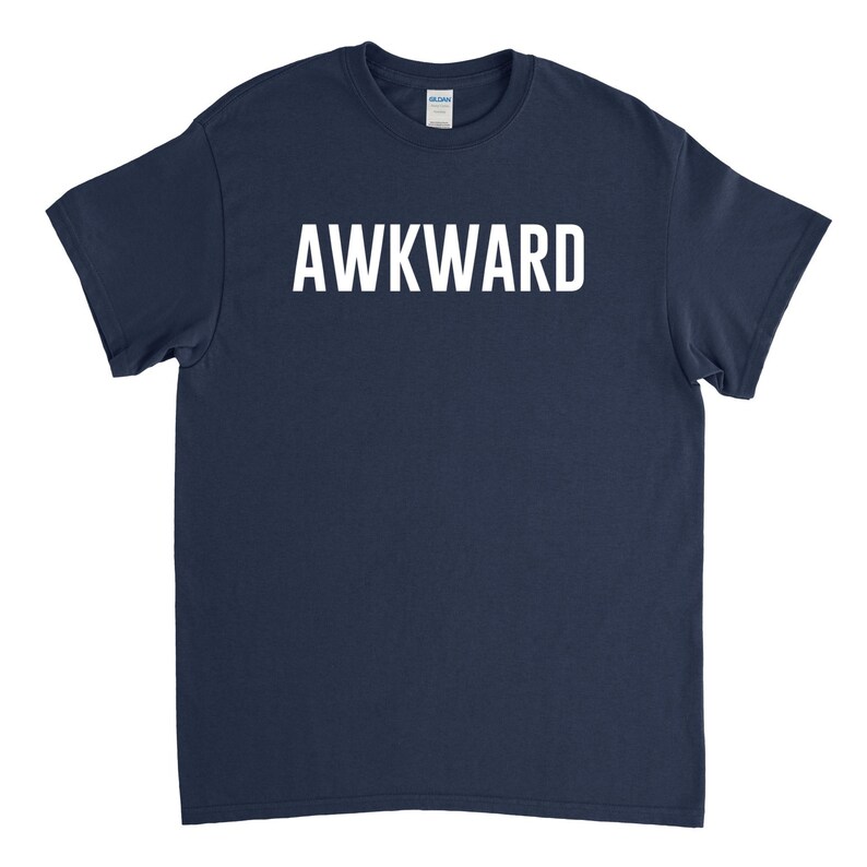 May include: A navy blue t-shirt with the word "AWKWARD" printed in white on the front.
