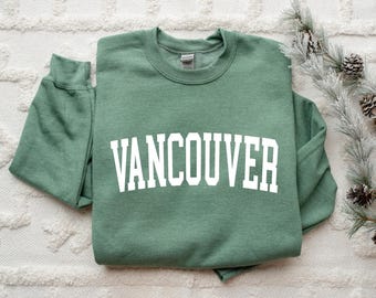 May include: A green sweatshirt with the word "Vancouver" printed in white on the front.