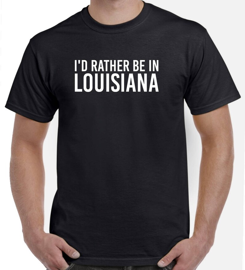 May include: Black t-shirt with white text that reads "I'd rather be in Louisiana".