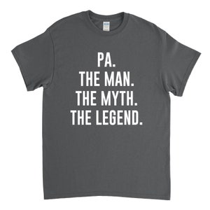 Puede incluir: Camiseta gris oscuro con texto blanco que dice "PA. THE MAN. THE MYTH. THE LEGEND."