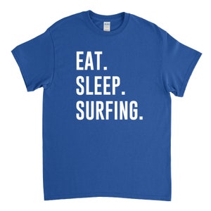 Puede incluir: Camiseta azul real con texto blanco que dice "EAT. SLEEP. SURFING."