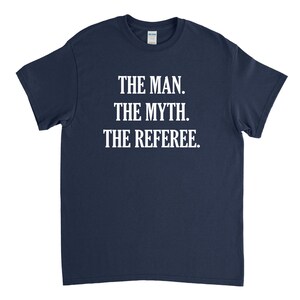 May include: A navy blue t-shirt with white text that reads "The Man. The Myth. The Referee."