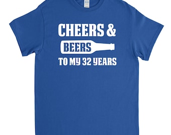 Könnte beinhalten: Ein königsblaues T-Shirt mit weißem Text, der "Cheers & Beers to my 32 years" lautet, mit einer Silhouette einer Bierflasche.