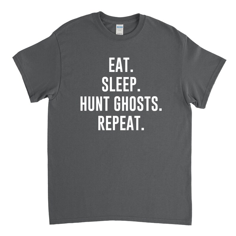 May include: A dark gray t-shirt with white text that reads "Eat. Sleep. Hunt Ghosts. Repeat."