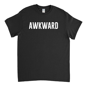 May include: Black t-shirt with the word "AWKWARD" printed in white on the front.