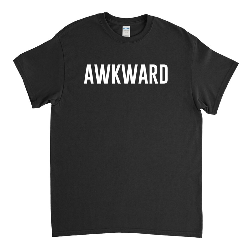 May include: Black t-shirt with the word "AWKWARD" printed in white on the front.