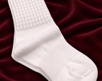 May include: A solid white crew sock featuring a thick, textured ribbed knit pattern on the upper cuff and a smooth, plain knit finish on the foot section. The sock has a reinforced heel and toe area with a snug, elasticized mid-foot band.