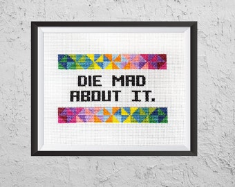 May include: A white cross-stitch embroidery with a colorful geometric pattern at the top and bottom. The text "DIE MAD ABOUT IT." is stitched in black thread in the center.
