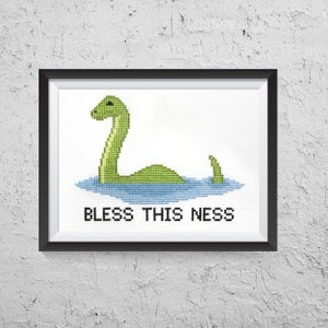 May include: A framed cross-stitch design featuring a green Loch Ness Monster with the text "Bless This Ness".