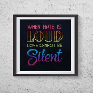 May include: A framed cross-stitch design with a black background and colorful text that reads "When hate is loud love cannot be silent".