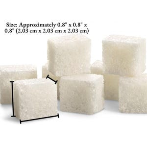 An image of several sugar cubes, showing the dimensions of Meliora Forever cocktail cubes. The dimensions are 0.8 inches (2.03 centimeters) cubed - length, width, and height.