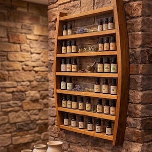 May include: A wall-mounted wooden shelf with a curved frame holding multiple small amber glass bottles of essential oils. The shelf features six horizontal tiers, with dried lavender sprigs and a small mortar and pestle placed among the bottles.