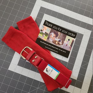 May include: Red baseball socks and a red and black baseball belt with a silver buckle. The belt is labeled "CHRIMPRO BRUTE BELT".