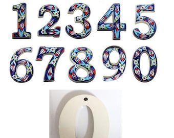 Puede incluir: Conjunto de diez números de casa de cerámica con un diseño floral azul y blanco. Los números son 1, 2, 3, 4, 5, 6, 7, 8, 9 y 0. Los números son todos del mismo estilo y tienen un fondo blanco.