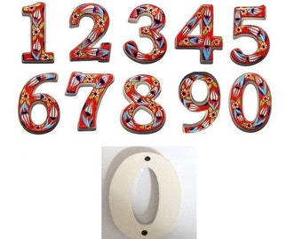 Puede incluir: Conjunto de diez números de casa de cerámica con fondo rojo y diseño floral. Los números son 1, 2, 3, 4, 5, 6, 7, 8, 9 y 0. El número 0 es blanco.