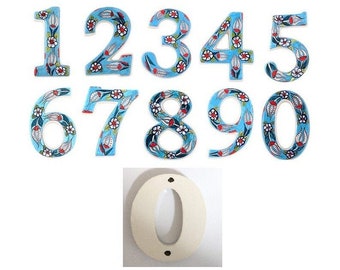 Puede incluir: Conjunto de diez números de casa de cerámica con fondo azul y diseño floral. Los números van del 1 al 9 y el 0. El número 0 también está disponible en una versión blanca lisa.