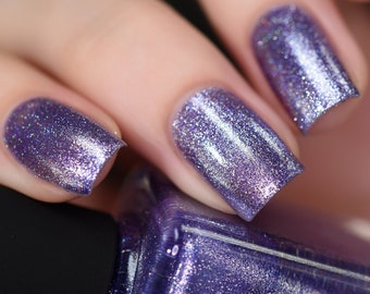 May include: Purple nail polish with a silver shimmer finish. The bottle is labeled "ND Lacquer".