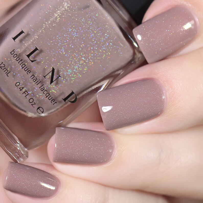 Peut inclure: Un flacon de vernis &agrave; ongles boutique ILNP dans la teinte "Dusty Rose". Le flacon est transparent et montre le vernis &agrave; ongles rose clair avec une finition chatoyante. Le flacon est &eacute;tiquet&eacute; avec le nom de la marque "ILNP" et le nom du produit "vernis &agrave; ongles boutique".