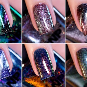 May include: Six different nail polishes with a holographic finish. The colors are a deep purple, a light pink, a dark red, a light blue, a dark blue, and a green. Each bottle has a black label with the word "NP" on it.