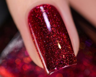 Puede incluir: Primer plano de una uña pintada con un esmalte de uñas rojo oscuro con un acabado de brillo rojo fino.