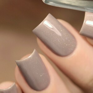 Peut inclure: Gros plan sur trois ongles peints avec un vernis &agrave; ongles brun clair avec un l&eacute;ger &eacute;clat.