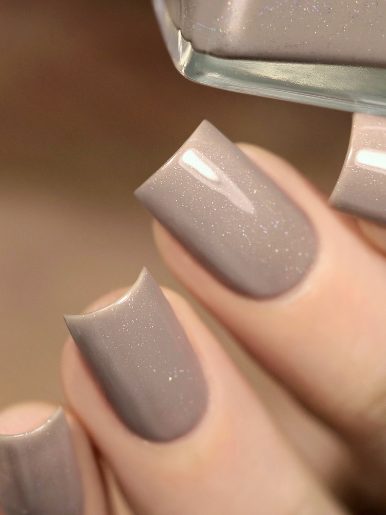 Peut inclure: Gros plan sur trois ongles peints avec un vernis &agrave; ongles brun clair avec un l&eacute;ger &eacute;clat.