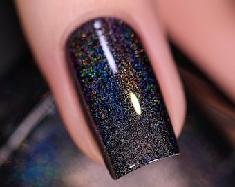 May include: Close-up of a fingernail with dark purple nail polish with iridescent glitter.