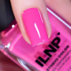 May include: A close-up of a fingernail painted with bright pink nail polish. The nail polish bottle is in the background and says "ILNP" in black letters.