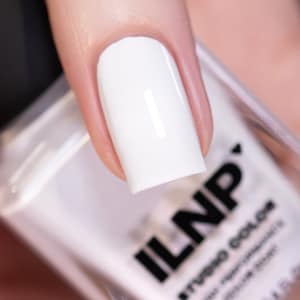 May include: A close-up of a white nail polish bottle with the brand name "ILNP" printed on the side. The bottle is clear and shows the white nail polish inside.