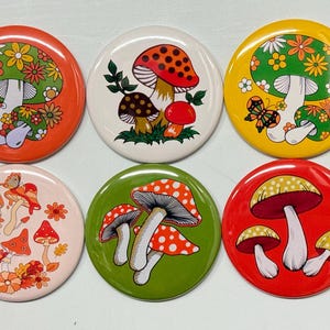 May include: Six round, colorful, decorative magnets featuring various mushroom designs with floral and geometric patterns. The magnets are perfect for adding a touch of whimsy to any refrigerator or metal surface.
