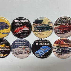 May include: Eight vintage-style round buttons with images of classic Chevrolet cars and the text "Chevrolet is First!"  The buttons are yellow, red, blue, black, and white.