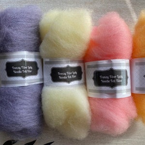 May include: Four skeins of needle felting fiber in purple, yellow, pink, and orange. Each skein is labeled "Frenzy Fiber Lady Needle Felt Fiber".