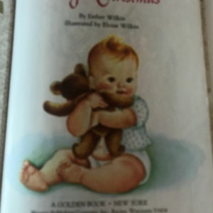 May include: A vintage children's book titled "Baby's Christmas" by Esther Wilkin, illustrated by Eloise Wilkin. The illustration shows a baby holding a brown teddy bear. The baby is wearing a diaper and a light blue top.