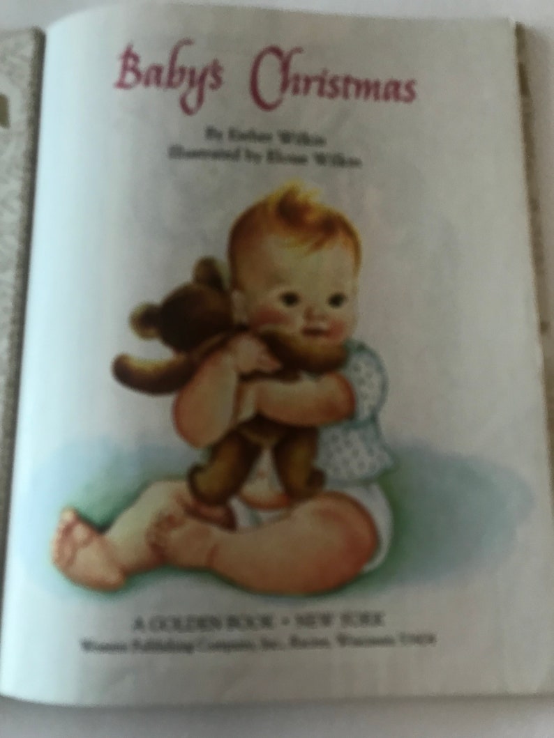 May include: A vintage children's book titled "Baby's Christmas" by Esther Wilkin, illustrated by Eloise Wilkin. The illustration shows a baby holding a brown teddy bear. The baby is wearing a diaper and a light blue top.