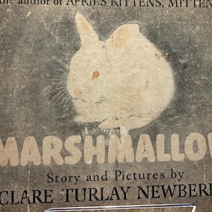 May include: A vintage hardcover book titled MARSHMALLOW with a dark gray cover featuring a white illustration of a rabbit. The text reads Story and Pictures by CLARE TURLAY NEWBERRY and By the author of APRIL'S KITTENS, MITTENS, etc.