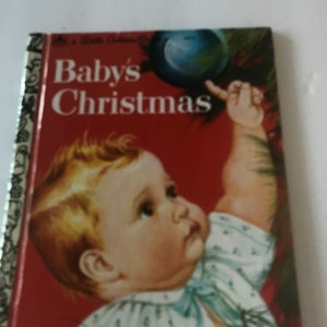 May include: A vintage children's book titled "Baby's Christmas" with a red cover. The cover features an illustration of a baby reaching for a Christmas ornament. The book has a gold spine.