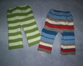 May include: Two pairs of striped knit pants. One pair is green and white, the other is blue, red, white, and gray.
