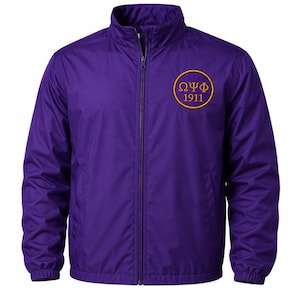 May include: A purple zip-up windbreaker jacket featuring a high collar and long sleeves with elastic cuffs. On the upper left chest, there is a circular gold emblem containing the Greek letters Omega Psi Phi and the year 1911 in gold text.