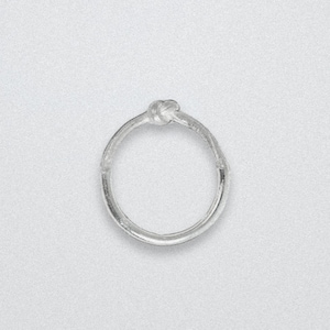 Könnte beinhalten: Ein silberner Ring mit einem Knotendesign. Der Ring ist kreisförmig mit einem Knotendetail oben. Der Ring ist vor einem weißen Hintergrund platziert.