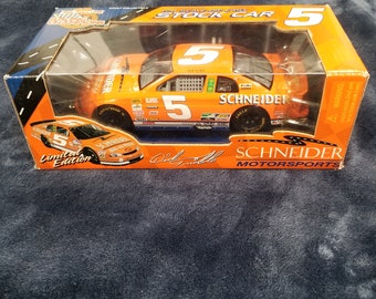 May include: A limited edition die-cast stock car with an orange body, black accents, and the number 5 on the side. The car is labeled "Schneider Motorsports" and has the signature "Dale Jarrett" on the box.