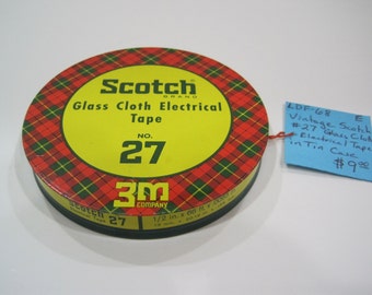 May include: A vintage tin of Scotch Brand #27 Glass Cloth Electrical Tape. The tin is red, yellow, and green with a plaid pattern. The label reads "Scotch Brand Glass Cloth Electrical Tape No. 27 3M Company 1/2 in. x 66 ft. x .0005"