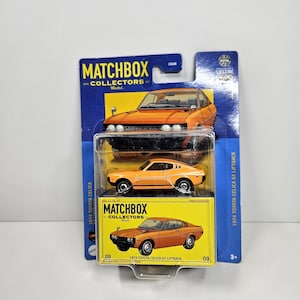 May include: A Matchbox Collectors 1974 Toyota Celica GT Liftback die-cast toy car in orange, encased in original blue and yellow blister packaging. The card features the vehicle name, the number 09, and the Matchbox Collectors logo in bold text.