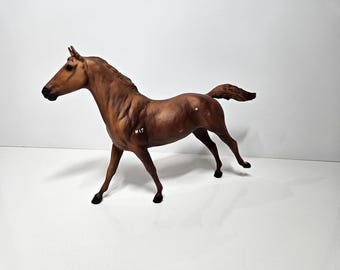 以下が含まれることがあります： 歩いているポーズの茶色の馬の置物。馬は濃い茶色のたてがみと尾を持ち、側面に「17」の数字があります。置物は白い背景に設定されています。