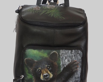 Leather Top Flat Zippered Backpack with a hand painted portrait Shenan, a black bear cub.